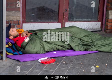 Slough, Berkshire, UK. 17th August, 2022. A homeless man sleeps in the doorway of Slough Railway Station. Credit: Maureen McLean/Alamy Stock Photo