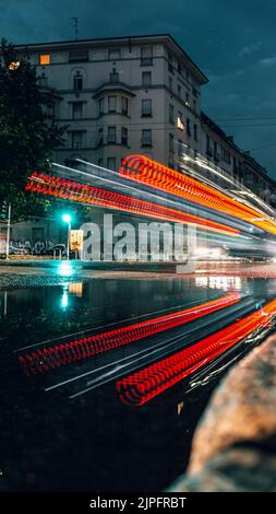 A vertical long exposure shot of traffic with light trails of cars at night in Milan Stock Photo