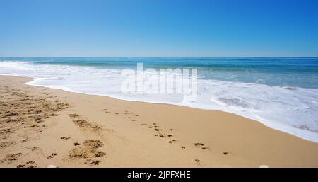 Sun Surf and Sandy Beach. A peaceful winter scene with surf waves rolling onto the beach at Kawana on the Sunshine Coast, Queensland, Australia. Stock Photo