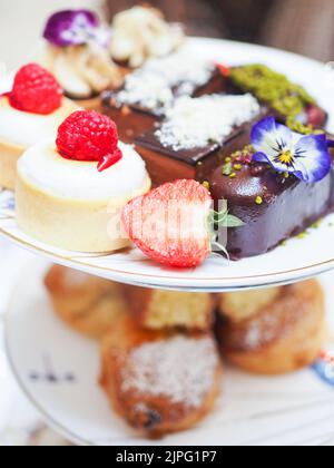 A closeup of delicious sweets decorated with fruits and flowers Stock Photo