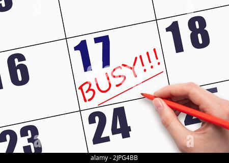 17th day of the month.  Hand writing text BUSY and drawing a line on calendar date. Business. Day of the year concept. Stock Photo