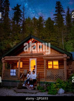 Wooden hut in an autumn forest, cabin off the grid, wooden cabin circled by colorful yellow and red fall trees. cabin in the woods British Colombia Canada Autumn. Couple men and women on vacation in Canada Stock Photo