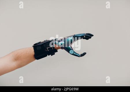Disabled man with artificial prosthetic hand close up male hand against gray background Stock Photo
