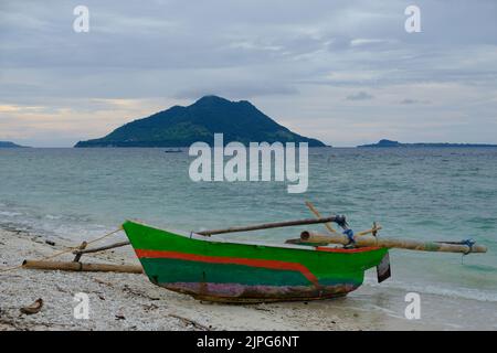 Indonesia Alor Island - Closeup Outrigger fishing boat moored off the Beach Stock Photo