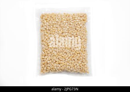 Peeled Pine Nut In Transparent Vacuum Medium Plastic Packaging On White Background. Stock Photo