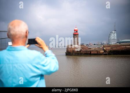 Bremerhaven, Germany. 18th Aug, 2022. Observers look at the leaning Mole tower. Parts of the north pier in Bremerhaven caved in during the night on Thursday. The entrance to the Geeste is closed. The ferry service of the Weser ferry also had to be suspended. Credit: Sina Schuldt/dpa/Alamy Live News Stock Photo