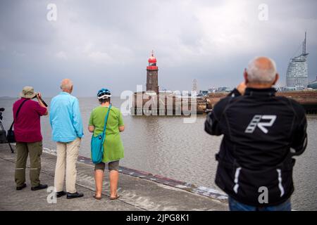 Bremerhaven, Germany. 18th Aug, 2022. Observers look at the leaning Mole tower. Parts of the north pier in Bremerhaven caved in during the night on Thursday. The entrance to the Geeste is closed. The ferry service of the Weser ferry also had to be suspended. Credit: Sina Schuldt/dpa/Alamy Live News Stock Photo
