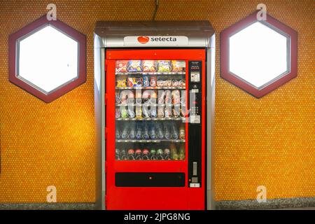 Vending machine in a subway station, flanked by two hexagonal windows. Stock Photo
