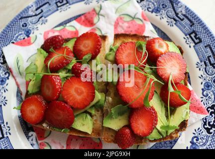 Strawberries and avocado on toast Stock Photo