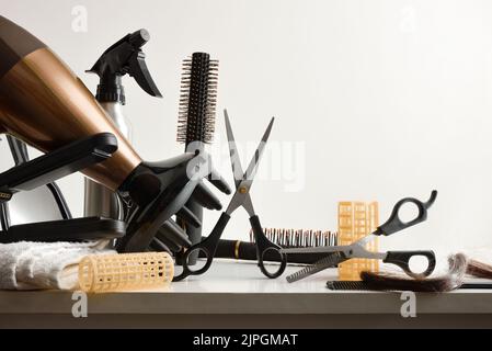 Hairdressing tools on white workbench with white isolated background. Front view. Horizontal composition. Stock Photo