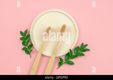 Two wooden toothbrushes on a white podium. Personal hygiene items Stock Photo