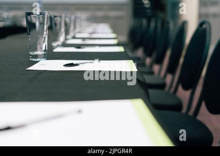 En Empty Row of Modern Chairs by a Table in a Hotel Conference Room Stock Photo