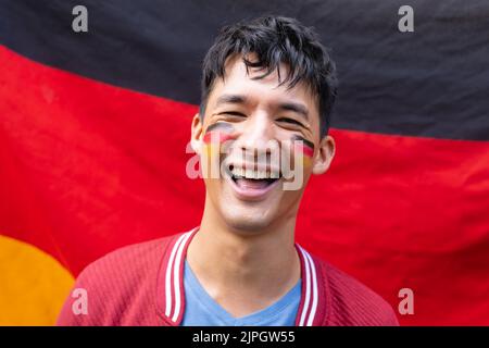 Portrait of happy biracial man smiling over flag of germany Stock Photo