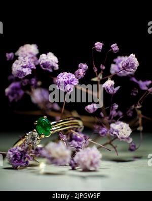 A closeup shot of the engagement rings with violet flowers Stock Photo