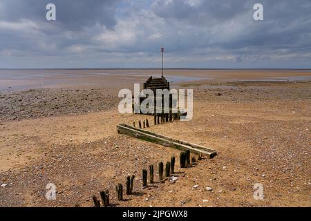 Dark clouds loom over Hunstanton beach at low tide. Stock Photo