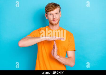 Photo of strict red hair guy pause wear orange t-shirt isolated on teal color background Stock Photo