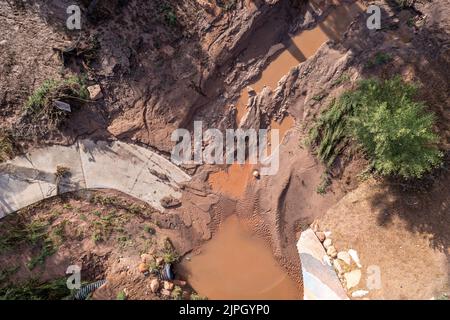 Severe erosion damage caused by flash flooding after vegetation loss upstream after a wildfire.  Moab, Utah. Stock Photo