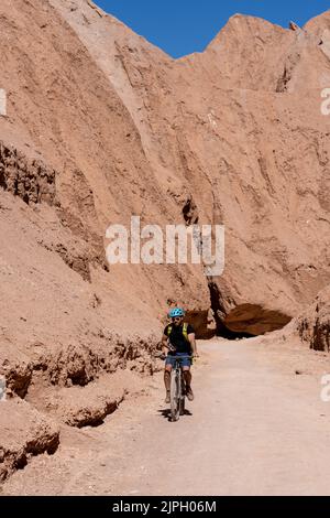 One male mountain biker on the trail in the Devil's Throat or Garganta del Diablo in the Atacama Desert in Chile. Stock Photo