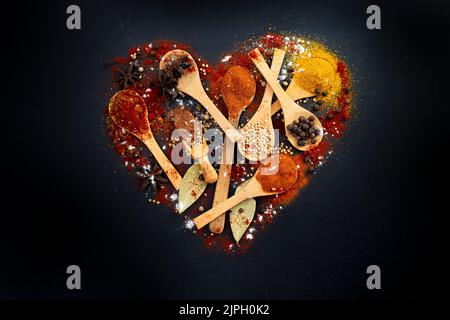 https://l450v.alamy.com/450v/2jph0k2/various-spices-and-wooden-spoons-arranged-in-a-heart-shape-isolated-on-black-background-2jph0k2.jpg