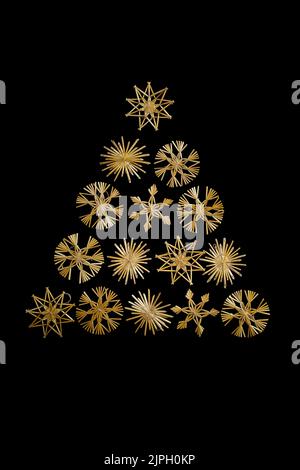 Christmas tree triangle made with straw snowflakes isolated on black background Stock Photo