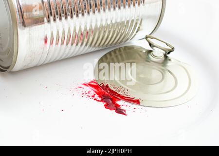 Aluminum tin can with blood splatter on white background, domestic injury  concept, close up Stock Photo
