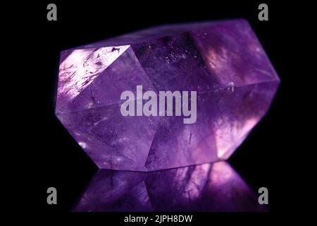 Macro mineral stone Amethyst crystal on a black background close-up Stock Photo