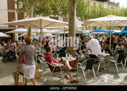 Pollenca, Majorca, Spain - September 14th 2008: A crowded outdoor cafe with other people walking around on market day. The market is held weekly Stock Photo
