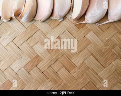 woven bamboo texture with garlic on the top edge Stock Photo