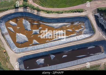 Aerial view of large slurry lagoons with membrane covers to prevent escape of ammonia, methane, carbon dixode, hydrogen sulfide and nitrous oxide Stock Photo