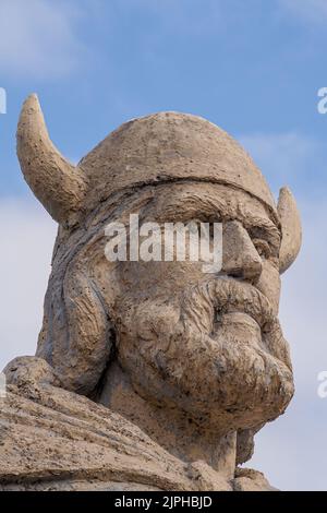 Side view of head of a Viking statue on waterfront of lake Winnipeg in Gimli, Manitoba, Canada under cloudy sky Stock Photo