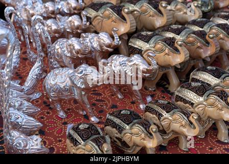 Metal and wooden figurines of Indian elephants with national ornaments. Souvenirs from India. Stock Photo