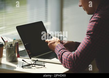 Cropped image of businessman sitting at table and checking smartphone Stock Photo