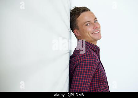 Portrait of cheerful man leaning on wall and smiling at camera Stock Photo