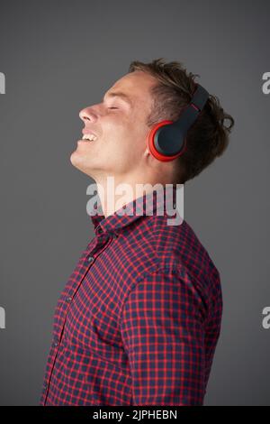 Smiling young manin headphones enjoying his favorite music Stock Photo