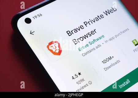 Brave Private web browser app seen in Google Play Store on the smartphone screen placed on red background. Close up photo with selective focus. Staffo Stock Photo