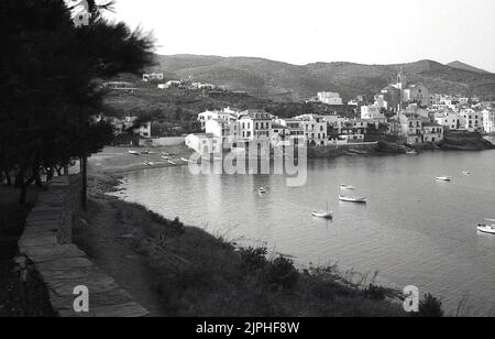 1960s, historical view from this era of the coastal town of Cadaqués, Girona, Spain. Pretty village houses built around a bay on the Cape de Creus peninsula on the Costa Brava of the Mediterranean. The Spanish surrealist artist, Salvador Dalí visited Cadaqués in his childhood, and later had a home in Port Lligat, a small village on a bay next to the town. Stock Photo