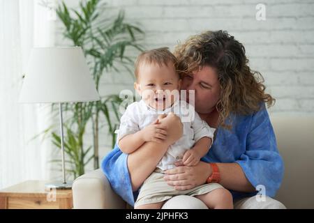 Woman enjoying playing with her laughing happy son Stock Photo