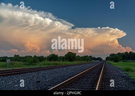 Hutchinson, Kansas - Storm clouds over railroad tracks at sunset in central Kansas. Stock Photo