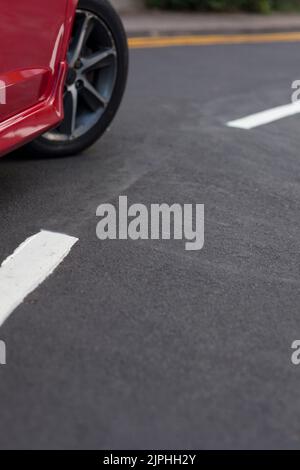 Red car at end of yellow lines Stock Photo