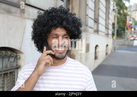 Multiracial man using mobile phone on the street Stock Photo