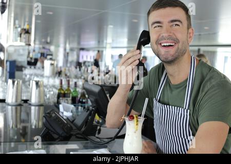Bar worker using landline phone Stock Photo