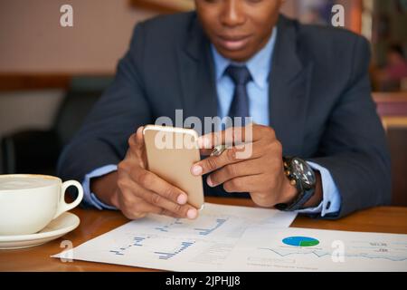 Cropped image of businessman checking smartphone when working with documents Stock Photo