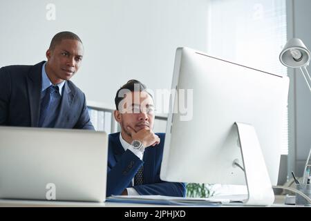 Financial managers analyzing market situation via computer Stock Photo