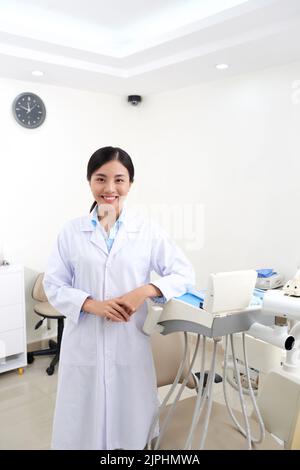 Pretty Vietnamese female dentist in her medical office Stock Photo