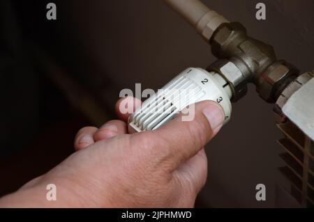 Controlling central heating temperature by adjusting thermostatic radiator valve Stock Photo