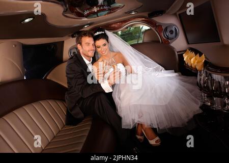 luxury, champagne, limousine, bridal couple, just married, prosperity, wealth, wealthiness, champagner, champagnes, limo, limos, limousines, bridal Stock Photo