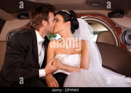 happy, kissing, limousine, bride, groom, bridal couple, just married, happies, limo, limos, limousines, brides, grooms, bridal couples, just marrieds Stock Photo