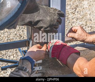 A worker installs a metal profile. Stock Photo