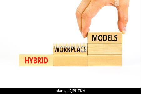 Hybrid workplace models symbol. Concept words Hybrid workplace models on wooden blocks. Businessman hand. Beautiful white background. Business hybrid Stock Photo