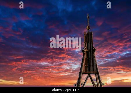 A low angle view of a wooden tower and a beautiful sky with scenic pink clouds Stock Photo